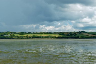 Sakin su, yukarıdaki dramatik gökyüzünü yansıtır..