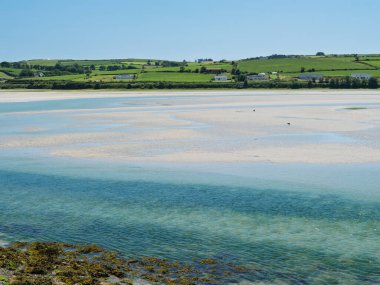 Ufuktaki yeşil tepelerin yanındaki geniş nehrin güzel manzarası beyaz bulutların altında.