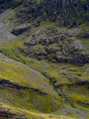 Dik bir yamaç yeşil çimenler ve kayalarla kaplıdır. Birkaç küçük şelale yamaçtan aşağı akıyor. Çok güzel bir doğal manzara..
