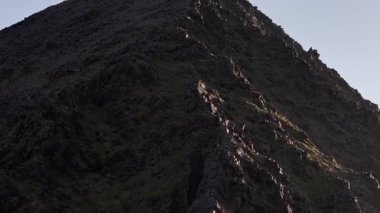 Bir haçla huzur dolu dağın tepesi, inancı ve azmi simgeliyor..