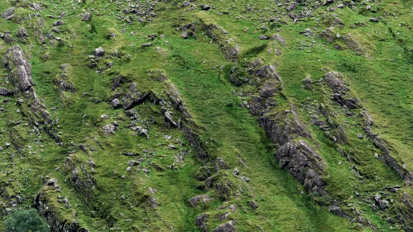Dik kayalık yamaçlar, yemyeşil çimenler ve yıpranmış taşlarla kaplı. Gün boyunca dokulu bir doğal ortam yaratıyor..