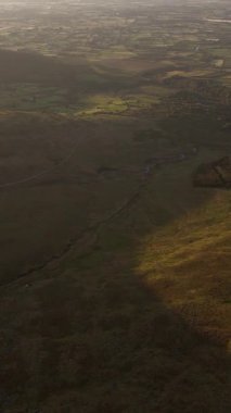 Kırsal arazinin havadan görünüşü. Kırsal kesimdeki ideal tarım arazileri. Gün batımında Yuvarlanan Tepeler. Vadi sıcak ışıkla yıkandı. Yukarıdan tarımsal arazi.