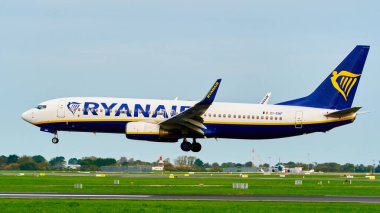 Dublin, İrlanda, 8 Ekim 2023. Bir Ryanair Boeing 737 uçağı iniş takımlarıyla yan taraftan bir havaalanı pistine yaklaşıyor..