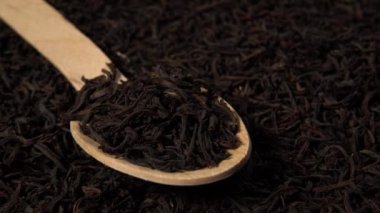 Tahta kaşıkta siyah çay yaprakları.