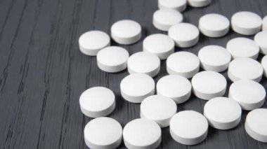 Ahşap bir yüzeye beyaz yuvarlak haplar. Coronavirus salgını için araştırma ve test etme fikri, COVID-19