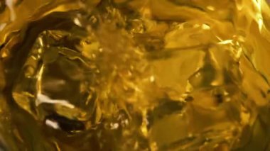 Makro buzu viskiyle bardağa düşürme sahnesi. Yavaş çekim sıçraması. - Yakın çekim. Döndürme