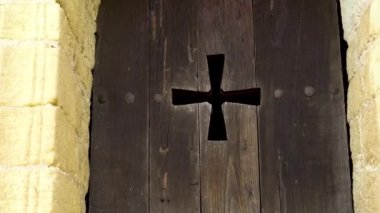 Ahşap, eski pencere panjurları ve yakın plan bir haç. Oviedo, Asturias, İspanya 'da antik bir kilisenin taş duvarı.