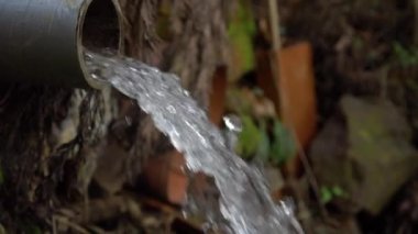 Plastik bir borudan su fışkırıyor. Çevre kirliliği kavramı