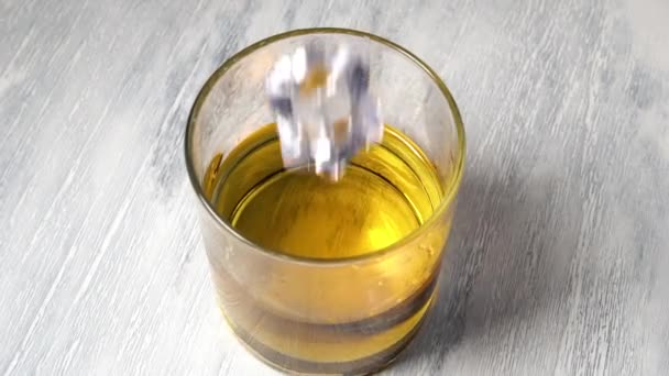 Falling Ice Cube Glass Whiskey Close Rotating Wooden Surface Slow — Stock Video