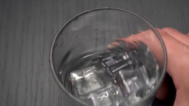 Χέρι Στροβιλίζεται Αλκοόλ Παγάκια Ένα Ποτήρι Grunge Παλιό Μαύρο Φόντο — Αρχείο Βίντεο