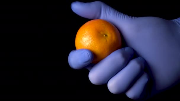 Mandarina Mano Con Guantes Médicos Azules Protectores Fondo Negro Cítricos — Vídeo de stock