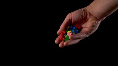 Ahşap renkli mantıksal çocuksu figürler insan elinden siyah arka plana düşer. Yavaş çekim