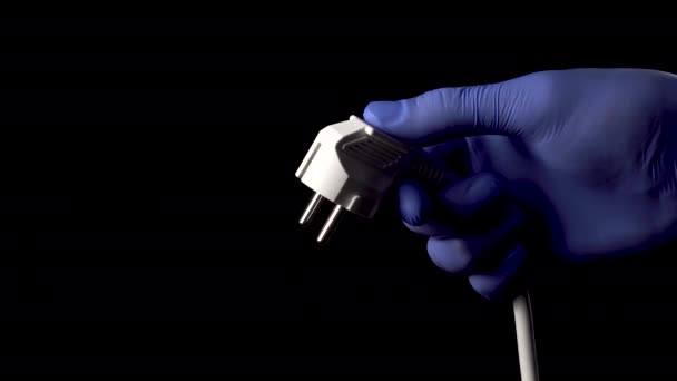 Χέρι Ένα Προστατευτικό Ιατρικό Γάντι Κρατά Ένα Ηλεκτρικό Βύσμα Μαύρο — Αρχείο Βίντεο