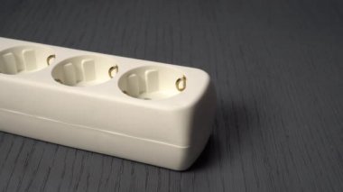 El beyaz bir elektrik uzatma kablosuna fişi bağlar..