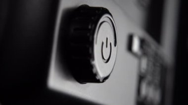 El, güç ayarlama düğmesine basar. Siyah plastik ışıklandırma cihazına yakın çekim. Makro çekim