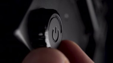 El, siyah plastik ışıklandırma cihazının güç kontrol düğmesini döndürür. Makro çekim