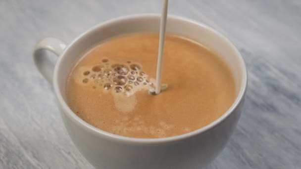 Выливание Молока Кофе Пеной Белой Чашке Сером Деревянном Столе Медленное — стоковое видео