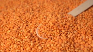 Tahta kaşıkta sarı çiğ mercimek. Düşüş. Baklagiller. Yavaş çekim