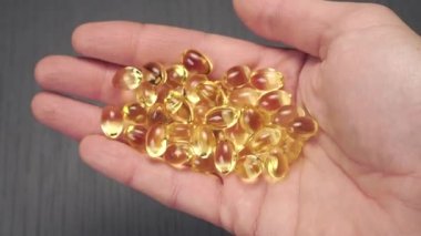 Gri ahşap arka planda Omega-3 kapsülleri hazır..