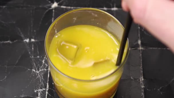 Koktail Dengan Jus Buah Kuning Oranye Dan Batu Dalam Gelas — Stok Video
