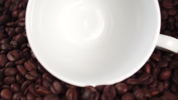 Geröstete Dunkle Kaffeebohnen Fallen Eine Weiße Keramiktasse Auf Einem Haufen — Stockvideo