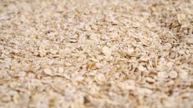 Yulaf ezmesi taneleri dönen bir yığının içine düşüyor. Yavaş çekim