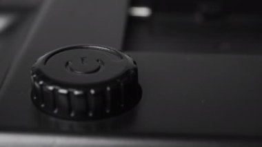 Aydınlatma ekipmanlarının güç parametrelerini ayarlamak için bir ayar çarkı. Siyah plastik düğme. Makro. Doli Vuruşu