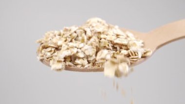 Kuru yulaf ezmeli tam ahşap tatlı kaşığı. Yavaş çekim kaşıktan düşüyor. Makro çekim