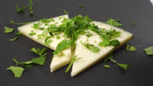 用切碎的欧芹把硬奶酪片包起来 在一块黑色的石头表面上Dolly Shot — 图库视频影像