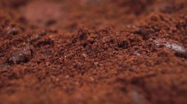 Dökülen suyla birlikte kavrulmuş kahve. Makro. Aromatik bir içecek hazırlıyorum. Kahverengi toz. Yavaş çekim