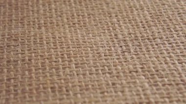 Bitkisel ilaçların bej kapsülleri yavaş çekimde bir çuval bezin üzerine düşüyor. Makro çekim