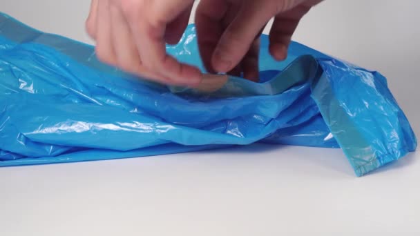 Mann Öffnet Eine Neue Blaue Plastiktüte Großaufnahme Auf Weißem Hintergrund — Stockvideo