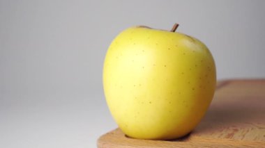 Tahta kesme tahtasındaki sarı elma. Kapatın. Doli Vuruşu