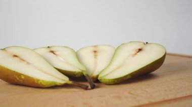 Olgun konferans armutları beyaz arka planda tahta kesme tahtasıyla ikiye bölünmüş. Kapatın. Doli Vuruşu