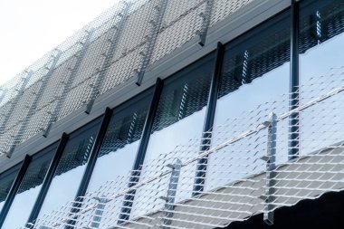 Bükülmüş metal ve cam cepheli modern bir bina. Kapatın. Geometrik şekiller ve yansıma