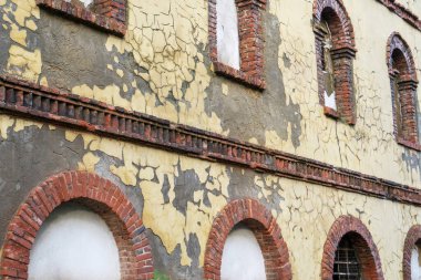 Kemerli camları olan eski tuğlalı bir duvar. Yosun ile yıpranmış antika duvar