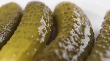 Yakından salatalık turşusu. Turşu damlaları yavaş çekimde düşer. Makro çekim