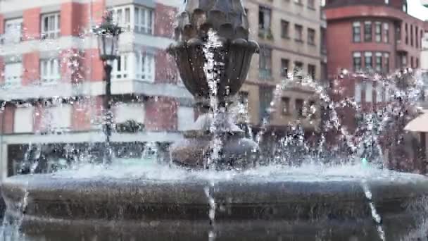 スペインのオビエドの欧州都市の広場にあるアンティークの噴水 古代の提灯や建物をぼかす ウォータージェットとスプラッシュが閉じます スローモーション — ストック動画