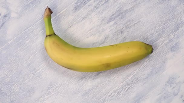 Hand Bedeckt Reife Gelbe Banane Mit Medizinischer Schutzmaske Auf Hölzernem — Stockvideo