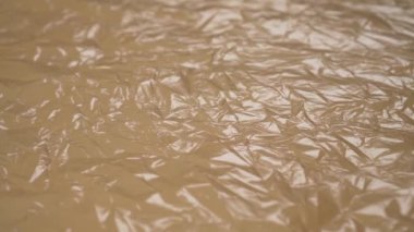 Buruşuk buruşuk plastik bej çöp torbası. Makro. Doli Vuruşu