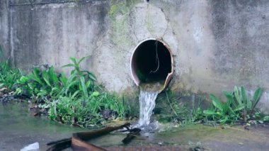 Kirli su borudan akar ve çevreyi kirletir. Çimento çatlağı tedavi tesisleri duvarı. Kanalizasyon, kanalizasyon arıtma tesisleri. Ağır çekim. Dramatik sinematik görünüm