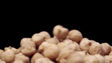 Nohutlar ağır çekimde siyah arka planda bir yığın halinde düşerler. Makro çekim