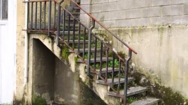 Eski tahrip olmuş beton merdivenler yosun ve küfle kaplanmış. Terk edilmiş ev