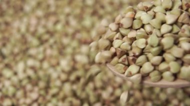 Tahta kaşıktan düşen yeşil karabuğday tohumları, yavaş çekimde, yakın çekim. Biyolojik ürün
