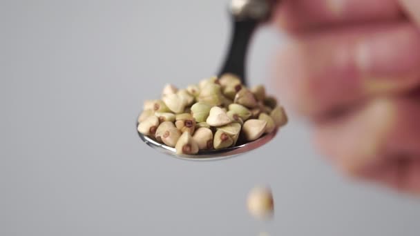 关闭绿色荞麦从金属勺子中以慢动作倾泻而下 大厨手感模糊 — 图库视频影像