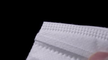 Siyah arka planda beyaz solunum maskesi KN95. Yakından dikiş atıldı. Makro doku. Sağlık çalışanlarını korumak için profesyonel anti-viral üniforma kavramı