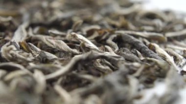 Beyaz arka planda Çin beyaz çayı. Kurutulmuş çay yaprakları yakın. Makro. Dolly Shot. Seçici odak