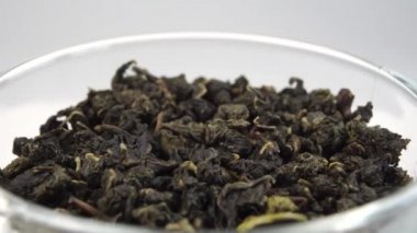 Kurutulmuş Çin yeşil çay yaprakları. Sıkıştırılmış çay yaprağı. Döndürme. Makro çekim