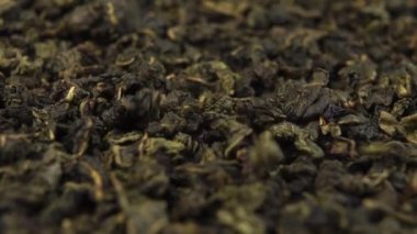 Geleneksel pişmemiş yeşil çay. Makro. Düşen kurumuş yapraklar yavaş çekimde. Döndürme.