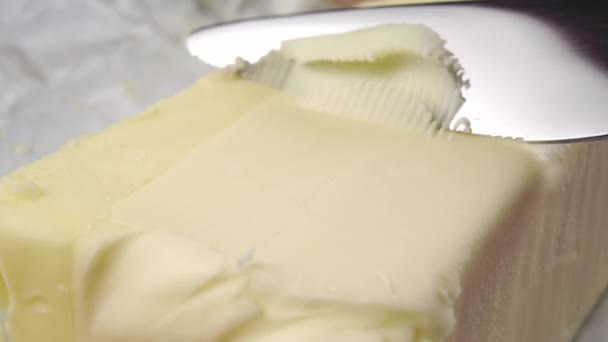 Ein Küchenmesser Schneidet Ein Stück Butter Mit Einer Locke Großaufnahme — Stockvideo